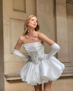 Elevate your special day with the luxurious Carmen Mini Dress. This strapless, princess style mini dress is custom made and features elegant draping for a formal touch. Perfect for the bride who wants to make a statement!