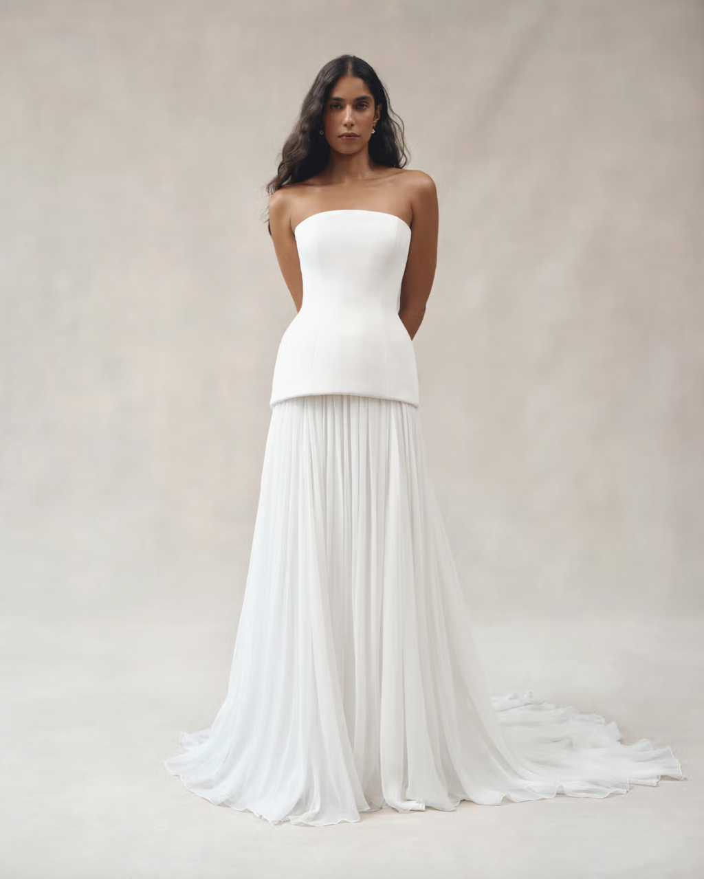 Experience luxury with the Clara Crepe Gown. Made from 100% satin silk crepe, this strapless gown offers a comfortable and elegant fit. The drop waist adds a touch of sophistication, making it the perfect choice for any special occasion. Available in a beautiful off-white color.