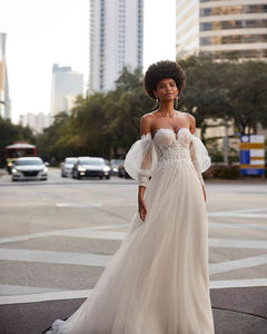 Expertly designed for the modern bride, the Kelia Gown combines traditional elements with contemporary style. Crafted with delicate tulle appliques and elegant lace, this dress features long puff sleeves and a flattering corset back. Perfect for any formal occasion, this gown will make any woman feel like a stunning bride.