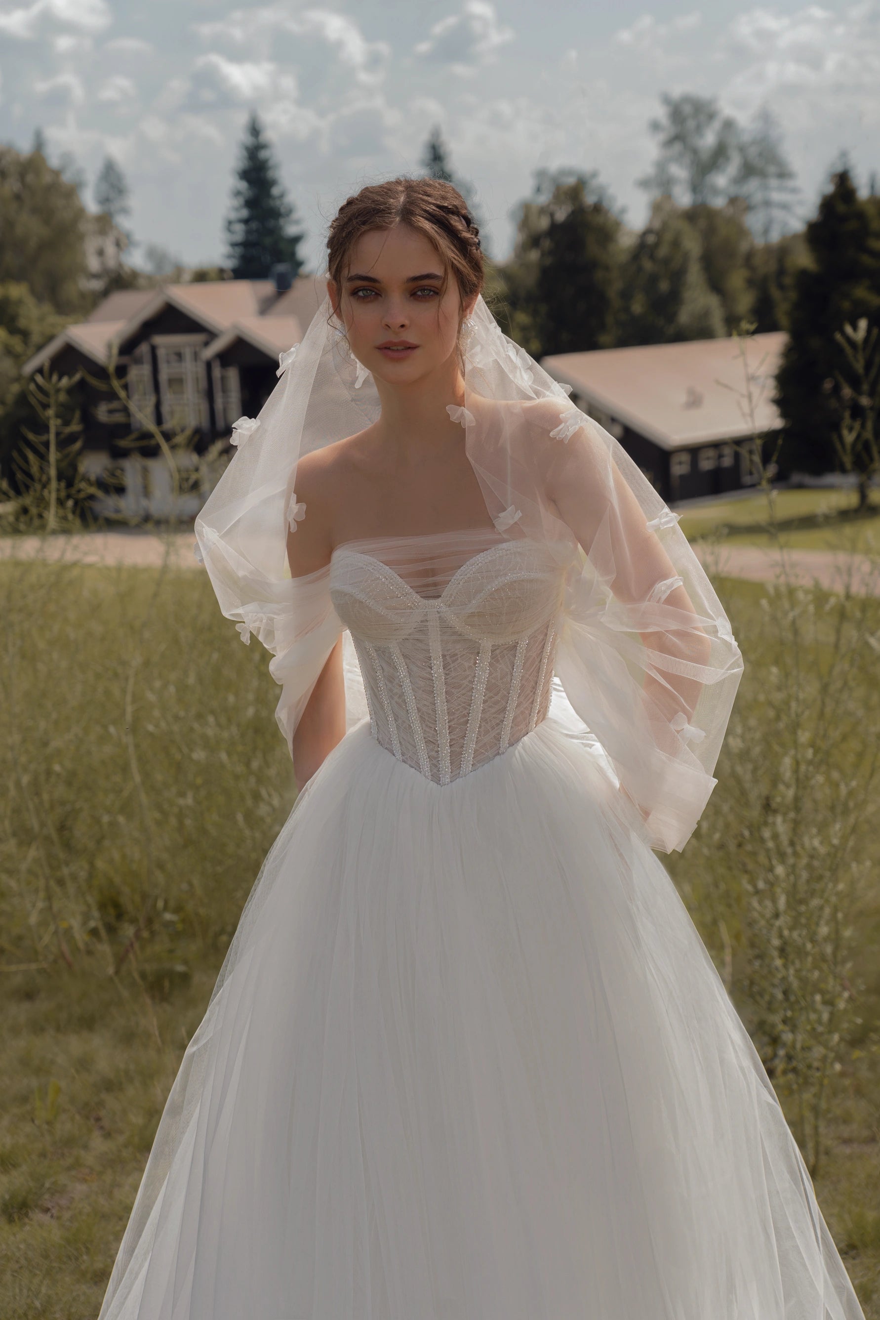 Experience the elegance and beauty of the Emfira Gown. This A-line wedding dress features voluminous cascading straps and a zippered back. Made with delicate tulle and sparkling glitter, your special day will be simply magical.