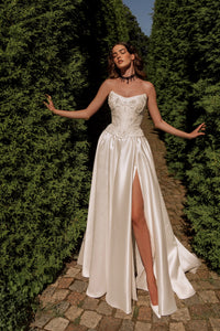 Radiate elegance on your special day with the stunning A-line Kristal Gown. The flattering strapless corset accentuates your silhouette, providing both support and charm. The lace-up back adds a touch of vintage charm and allows for a customized fit. With its graceful flow and long train, this gown makes a stunning statement as you walk down the aisle.