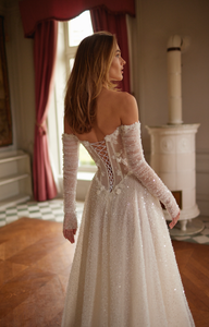 The Marine Gown is the epitome of luxury and elegance. With its off-the-shoulder design and delicate pearl detailing, this A-line wedding dress will make any bride feel like a princess on her special day. The long sleeves provide a touch of sophistication, while the bespoke tailoring ensures a perfect fit. Say "I do" in style with this stunning gown.