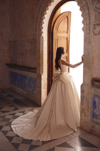 This stunning satin ballgown features a square neckline adorned with elegant pearls, a flattering basque waist, and a signature bow for added charm. Perfect for formal occasions, this gown will make you feel like royalty with its timeless design and luxurious details. Treat yourself to a touch of elegance with the Blanche Gown.