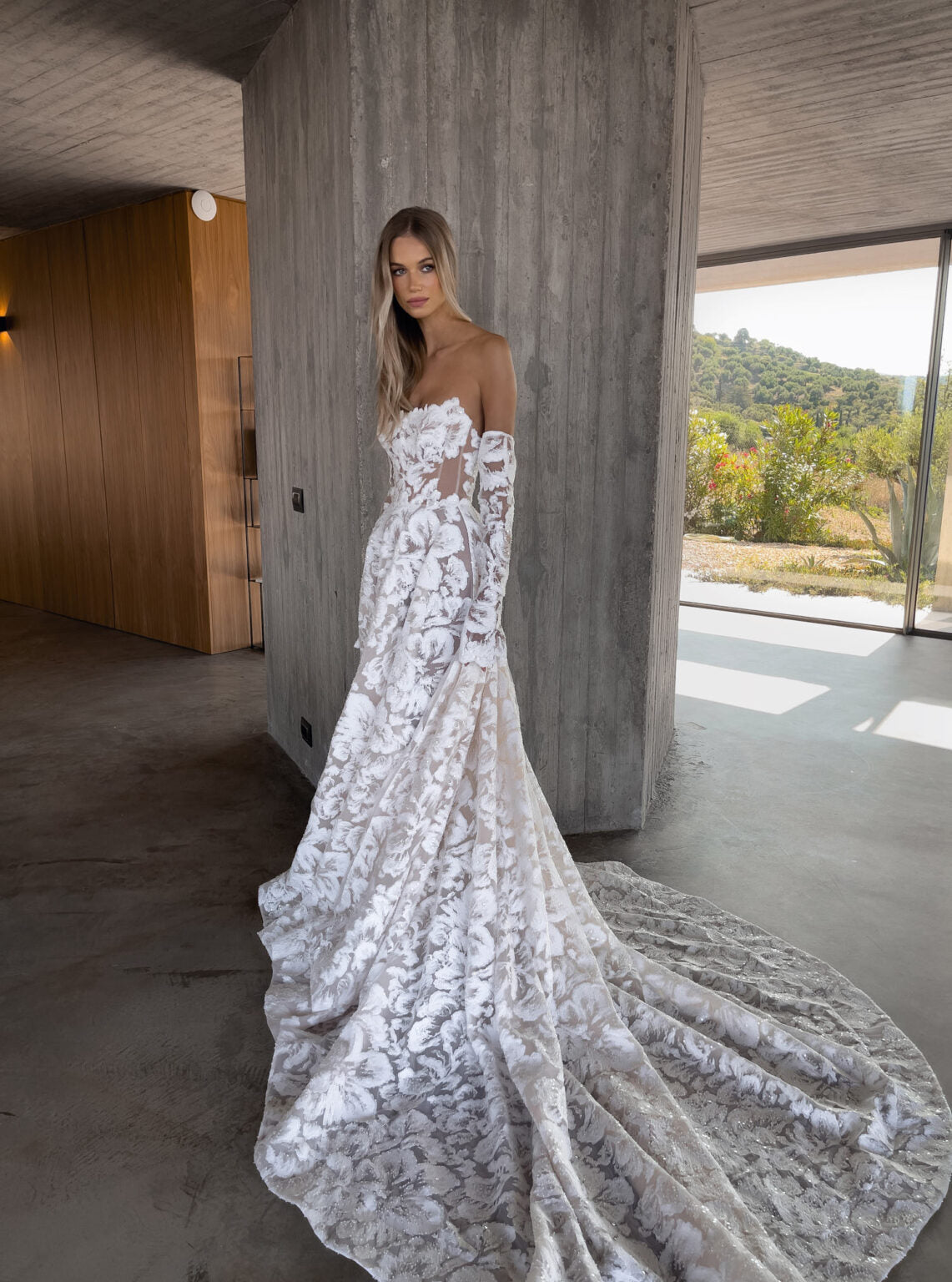 Indulge in the luxurious and exotic Zoey Gown. The stunning painterly corset and magnificent fabric, adorned with exotic flowers, exude elegance and grace. Perfect for an Italian wedding, the dramatic sleeves and long train add a touch of drama and sophistication. Be the center of attention with Zoey.