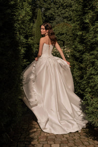 Radiate elegance on your special day with the stunning A-line Kristal Gown. The flattering strapless corset accentuates your silhouette, providing both support and charm. The lace-up back adds a touch of vintage charm and allows for a customized fit. With its graceful flow and long train, this gown makes a stunning statement as you walk down the aisle.