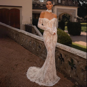 The Robe Rosalinda combines intricate lace details with a mermaid silhouette for a charming and elegant wedding dress. With long sleeves and a sweetheart neckline, this dress is perfect for a romantic and timeless look. Stand out on your special day with this stunning dress.