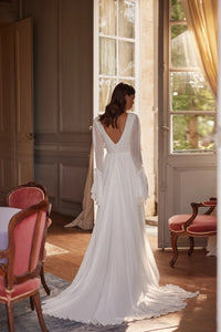 Introducing the Robe Juliette, a boho style wedding dress perfect for the free-spirited bride. With its lightweight ivory chiffon fabric and small train, this dress is both comfortable and elegant. The deep V-neck corset and open back add a touch of allure, while the flowy sleeves and delicate velvet belt add a romantic and feminine touch. Feel beautiful and carefree on your special day with the Robe Juliette.