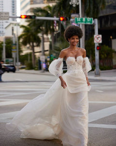 Expertly designed for the modern bride, the Kelia Gown combines traditional elements with contemporary style. Crafted with delicate tulle appliques and elegant lace, this dress features long puff sleeves and a flattering corset back. Perfect for any formal occasion, this gown will make any woman feel like a stunning bride.