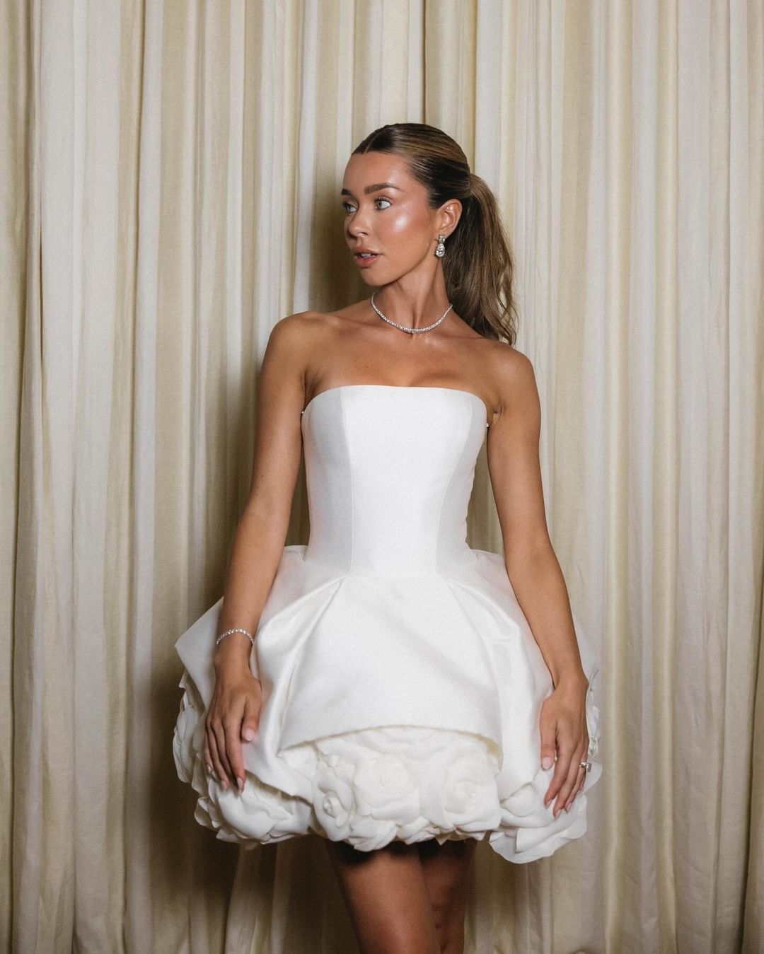 Experience the perfect blend of elegance and fun with our Robe Frida! This show stopping mini dress features a corsetted bodice and a stunning organza peony covered skirt. It's the ideal choice for a bride wanting a short statement dress or a glamorous second look for the reception. Perfect for a hens party too!