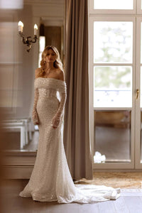 This Marcela Dress features stunning sequins adorning the entire mermaid-style silhouette, making it the perfect choice for a glamorous wedding look. The intricate detailing and form-fitting design will highlight your curves, while the sparkling embellishments add a touch of luxury. Make a statement on your special day with this gorgeous dress.