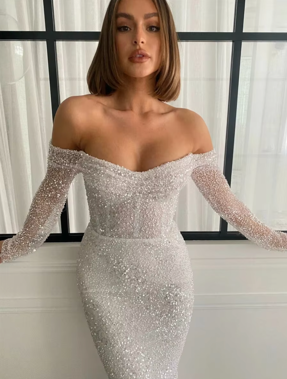 The Kaya Gown is the perfect choice for a glamorous bride. Its three-quarter length sleeves and stunning corset design with off-the-shoulder detail add a touch of elegance. The back zipper and button closure make it easy to wear, and its formal evening style is guaranteed to make you feel fashionable on your special day.