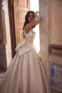 This stunning satin ballgown features a square neckline adorned with elegant pearls, a flattering basque waist, and a signature bow for added charm. Perfect for formal occasions, this gown will make you feel like royalty with its timeless design and luxurious details. Treat yourself to a touch of elegance with the Blanche Gown.