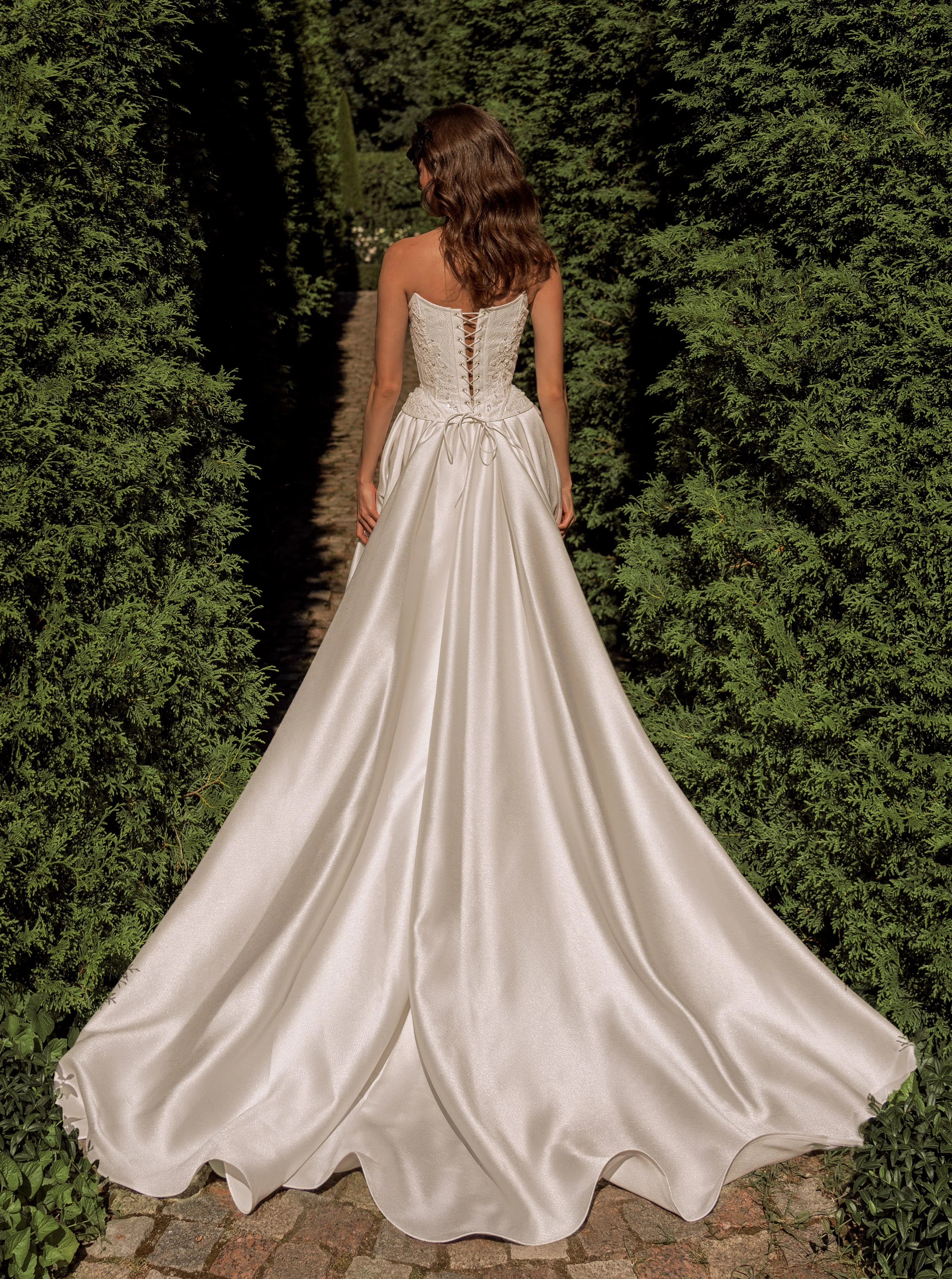 Radiate elegance on your special day with the stunning A-line Kristal Gown. The flattering strapless corset accentuates your silhouette, providing both support and charm. The lace-up back adds a touch of vintage charm and allows for a customized fit. With its graceful flow and long train, this gown makes a stunning statement as you walk down the aisle.