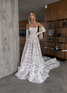 Indulge in the luxurious and exotic Zoey Gown. The stunning painterly corset and magnificent fabric, adorned with exotic flowers, exude elegance and grace. Perfect for an Italian wedding, the dramatic sleeves and long train add a touch of drama and sophistication. Be the center of attention with Zoey.