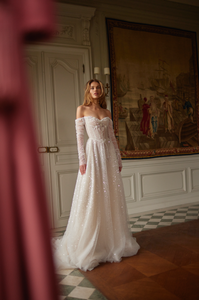 The Marine Gown is the epitome of luxury and elegance. With its off-the-shoulder design and delicate pearl detailing, this A-line wedding dress will make any bride feel like a princess on her special day. The long sleeves provide a touch of sophistication, while the bespoke tailoring ensures a perfect fit. Say "I do" in style with this stunning gown.