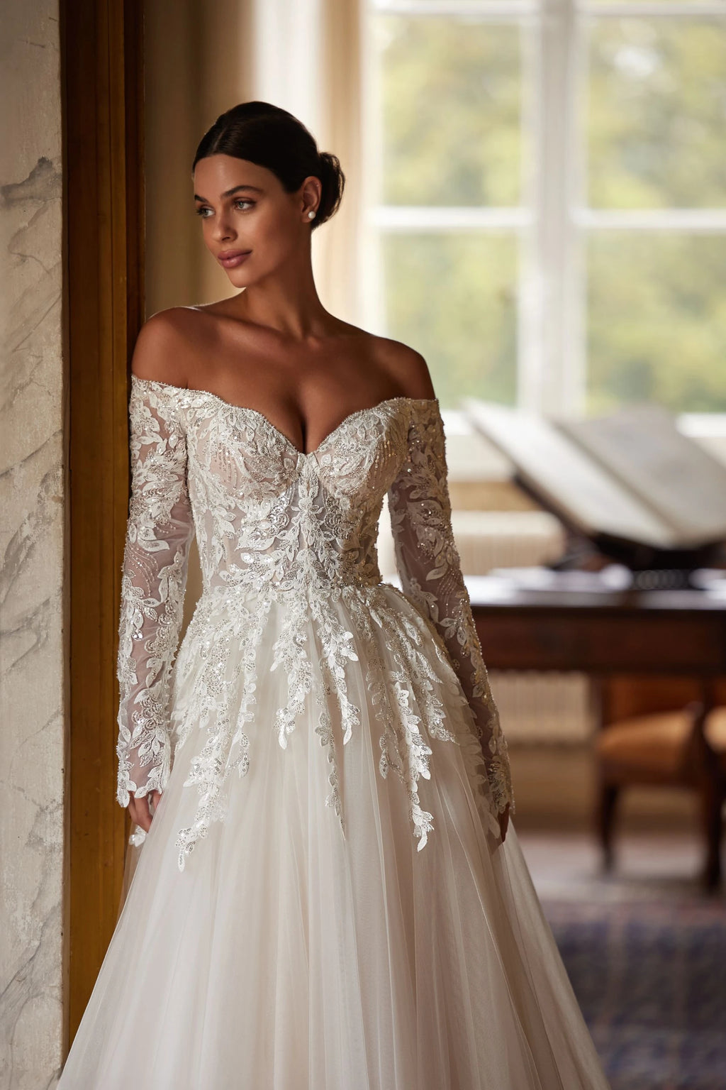 Introducing the Regina Gown, a light skin A-line dress that will make any bride the star of the wedding. The semi-sheer corset with a deep heart cutout and embroidered lace patterns adds a seductive touch, while the fluffy skirt and luxurious train create a stunning silhouette. Available in ivory.