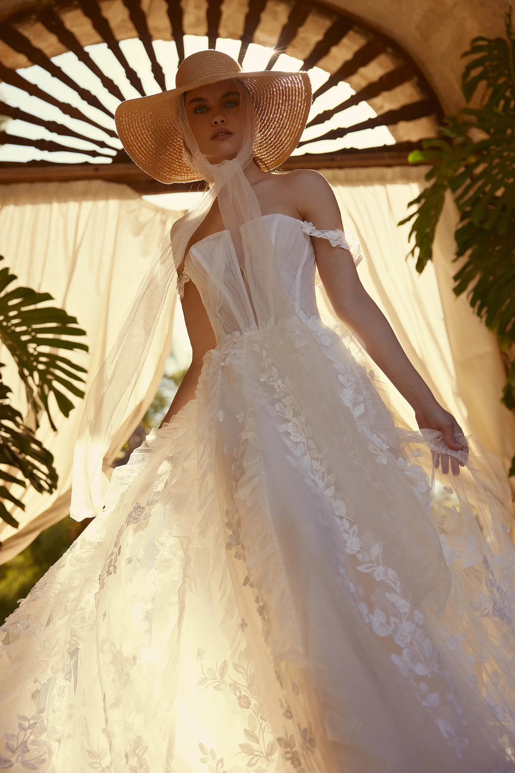 Channel your inner risk-taker on your big day with the one-of-a-kind Blossom Gown. Featuring delicate lace appliques that flow down the skirt and complete the train, this dress is perfect for the adventurous bride. The detachable straps add an extra touch of uniqueness to this bold and beautiful gown.