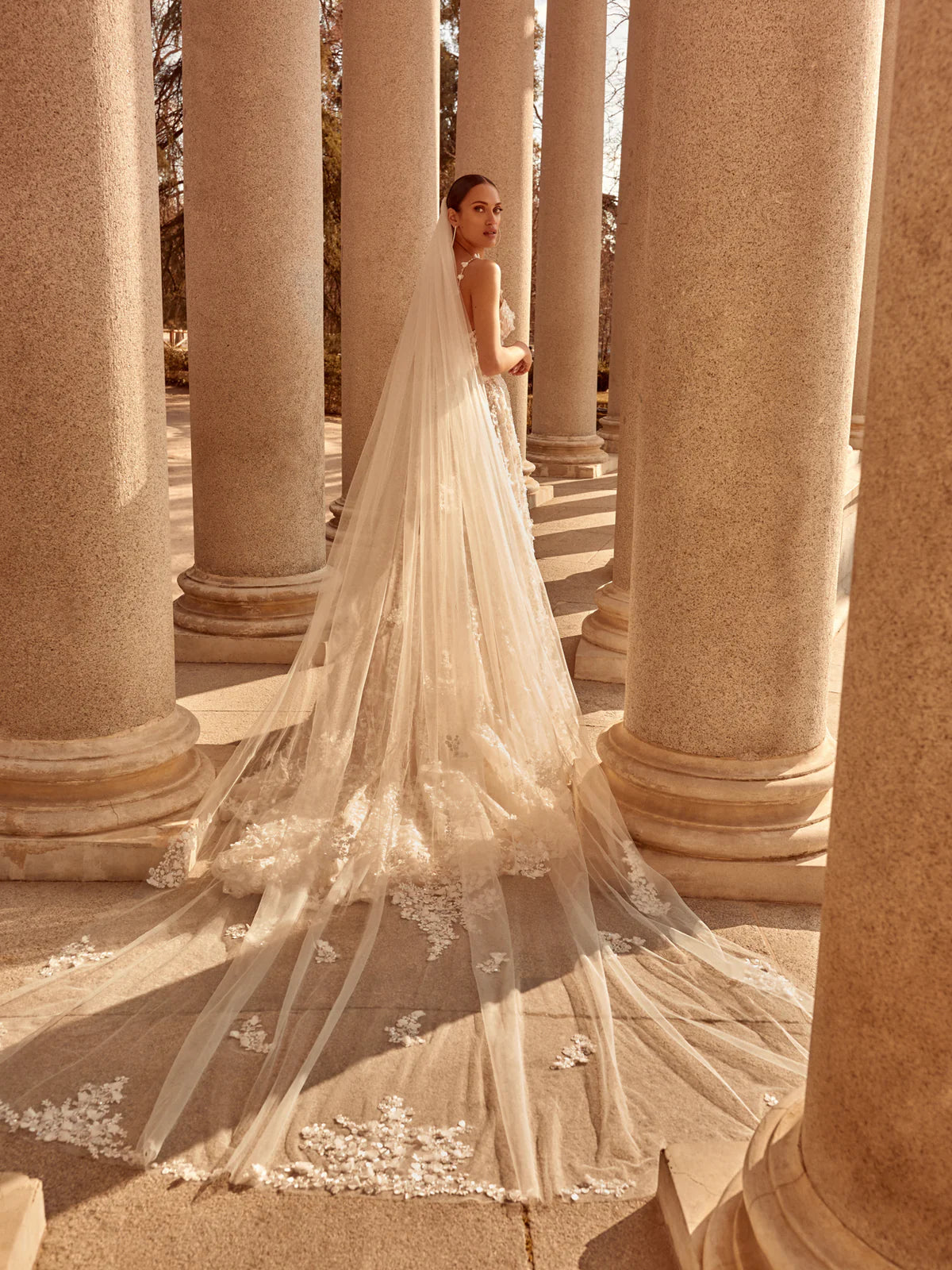 Eleina is the embodiment of opulent bridal elegance—an exquisite garment where each and every stitch, detail, and cut is thoughtfully considered. Drawing inspiration from the fervent emotions of love, desire, and celestial beauty, the scoop neck and goddess-like silhouette effortlessly transitions from the ceremony to the festivities, enhanced by a layered ball gown overskirt that adds depth and texture for a captivating second look. The delicate three-dimensional flower embroidery and petal-adorned straps 