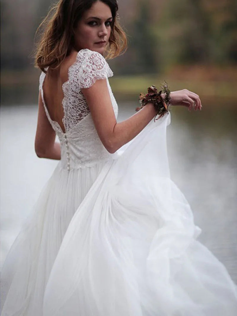 Make your special day even more perfect with Dress Arlene. This beautiful summer boho wedding dress features a V neckline and cap sleeves, perfect for a beach wedding. Crafted from chiffon, it exudes effortless elegance and will have you feeling comfortable and stunning all day long.