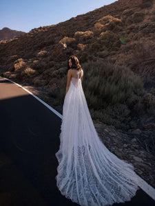 Introducing Dress Maddie, a stunning backless, sleeveless wedding dress with an O-neckline and intricate lace applique. The court train and illusion tulle add a touch of elegance, making it the perfect choice for the sophisticated bride. Be the epitome of grace and beauty on your special day.