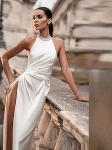 Turn heads in a memorable way on your special day with the Henrietta robe. Featuring a wedding dress high neckline, simple beads, and a slit skirt, this breathtaking bridal gown is both elegant and timeless. Bask in the attention with the stunning backless design. You’ll be a vision of beauty in this wedding dress.