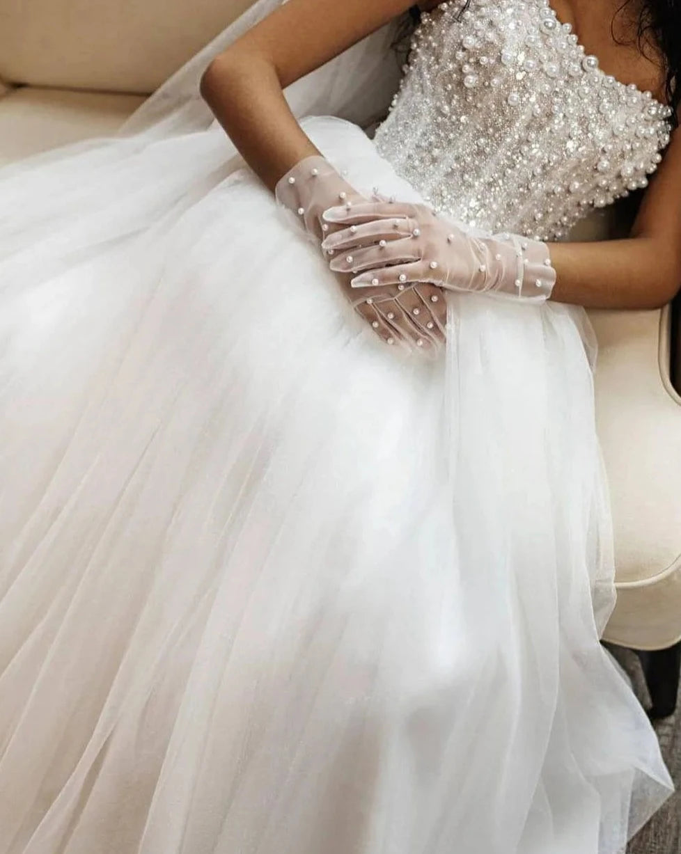 Step into a world of luxury and elegance with the Robe Evaine, a stunning wedding dress adorned with delicate pearls and intricate beading. This court train tulle dress is designed for the daring bride who wants to make a bold statement on her special day. Dare to be different and turn heads with the Robe Evaine!