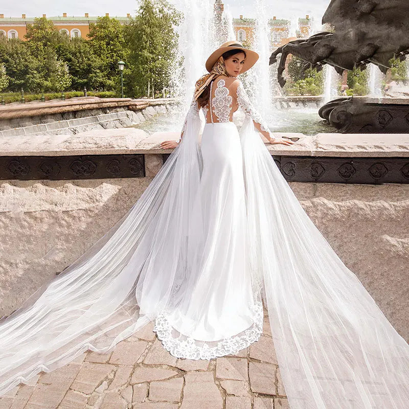 Introducing the Robe Lunete - a boho mermaid wedding dress that will make you feel like a mermaid queen! Featuring delicate lace appliques, illusion tulle, and stylish long sleeves, this dress is the perfect choice for a bride looking for a unique and stunning look on her special day. The shawl adds an extra touch of elegance and can be styled in multiple ways. Say yes to this button-up beauty!