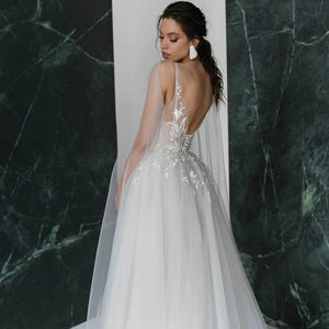 Get ready to turn heads in our Robe Nanou wedding dress. Boasting a V neck, exquisite embroidery, lace, and tulle, this A Line gown is custom-made to perfection. Leave a lasting impression with its open back, elegant pearls, and see-through detailing. The high split shoulder train adds a touch of glamour, making it the perfect choice for your special day.