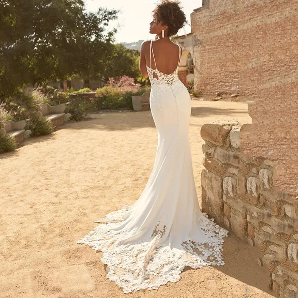 Expertly crafted with delicate lace appliques, the Dress Marietta is a stunning wedding dress with spaghetti straps and a flattering mermaid silhouette. Perfect for a beach wedding, the backless design adds a touch of allure to this elegant gown. Embrace your inner bride in the Dress Marietta.