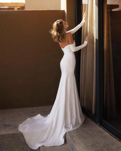 Elevate your bridal look with the Robe Magdalen. Its mermaid silhouette, V-neckline, and backless design combine for a simple yet elegant wedding gown. The sweeping train adds a touch of drama to make you feel like a true bride. Perfect for an unforgettable wedding party.