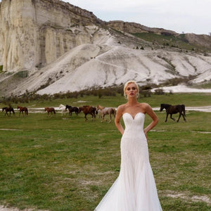 Elevate your wedding day with the grace and beauty of our Robe Finetta. Crafted with a strapless sweetheart neckline and mermaid silhouette, this dress adds a touch of elegance to your special day. The intricate sequin detailing and beachy vibes make it the perfect choice for a seaside celebration.