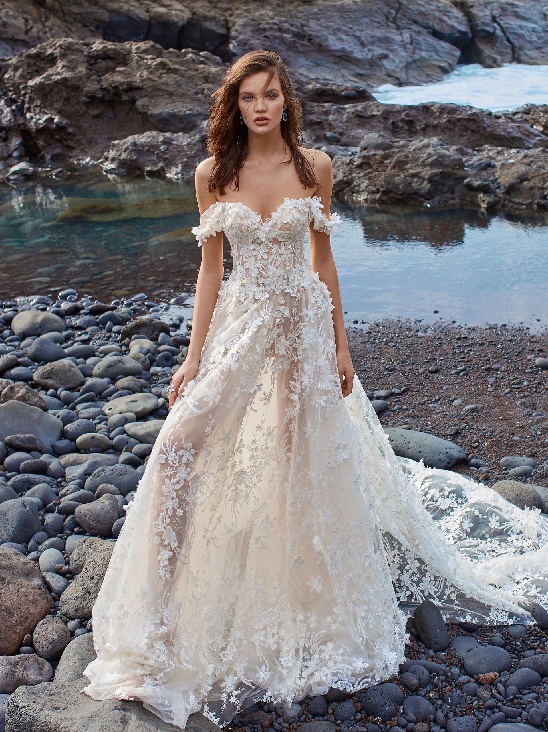 Indulge in luxury with our Robe Appoline, the perfect off-shoulder wedding dress for a beach destination. Made with high-quality lace, this vestido de novia exudes elegance and sophistication. Feel like a goddess on your special day with this exclusive piece.