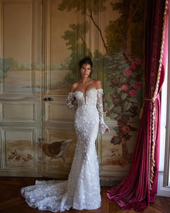 Elevate your bridal elegance with Robe Beline. This luxurious dress features a stunning lace design and a figure-hugging mermaid silhouette that will make you feel like a true queen on your special day. The long-sleeved, off-shoulder design adds a touch of romance and sophistication to this must-have wedding dress.