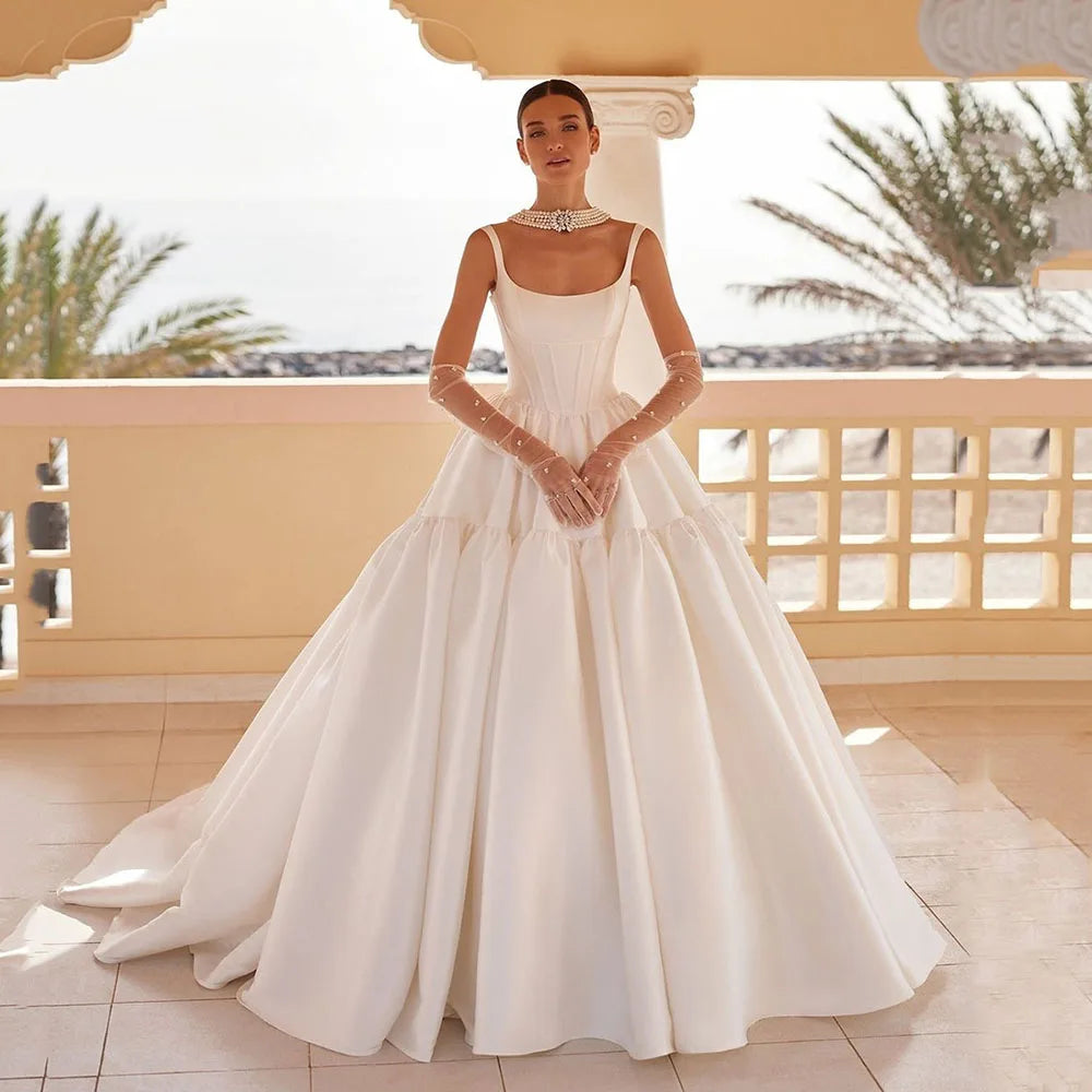 Experience the timeless elegance of the Britania Gown. Featuring a princess-cut silhouette and a square neckline, this Mikado wedding dress exudes sophistication and romance. Crafted with exquisite attention to detail, it is the perfect choice for brides seeking a classic and feminine look on their special day.