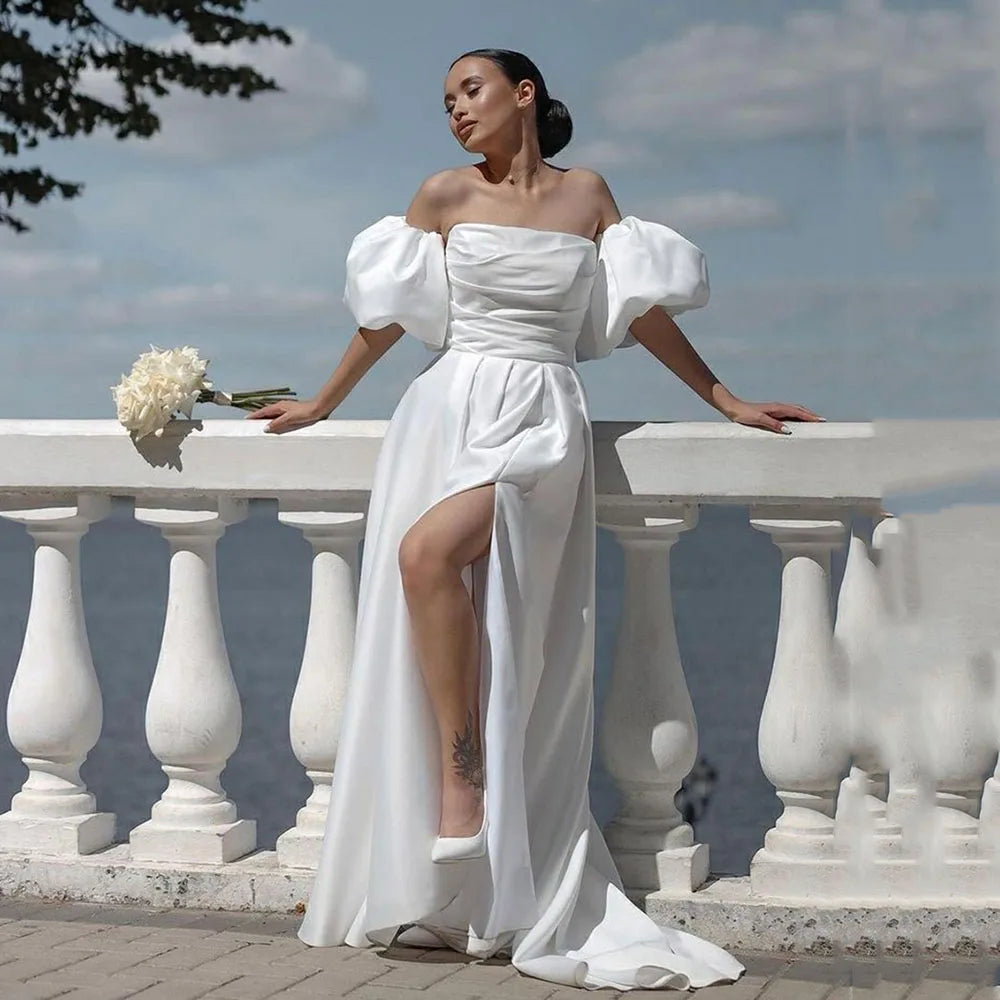 The Robe Sacha is the perfect choice for any beach or destination wedding. Its off-the-shoulder design and short sleeves add a touch of elegance, while the side split adds a sexy and modern twist. Made of high-quality satin, this dress is both stylish and comfortable, making it the ideal choice for any bride.