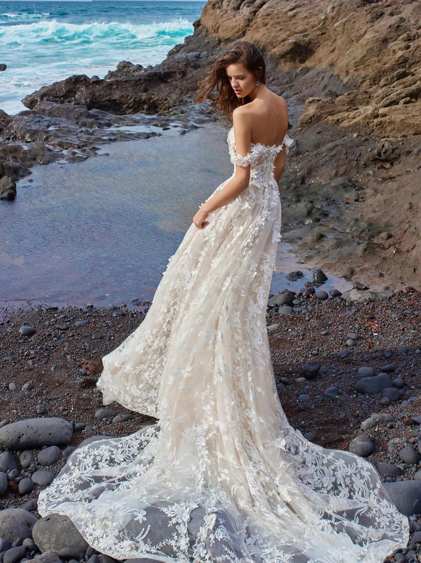 Indulge in luxury with our Robe Appoline, the perfect off-shoulder wedding dress for a beach destination. Made with high-quality lace, this vestido de novia exudes elegance and sophistication. Feel like a goddess on your special day with this exclusive piece.