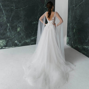 Get ready to turn heads in our Robe Nanou wedding dress. Boasting a V neck, exquisite embroidery, lace, and tulle, this A Line gown is custom-made to perfection. Leave a lasting impression with its open back, elegant pearls, and see-through detailing. The high split shoulder train adds a touch of glamour, making it the perfect choice for your special day.