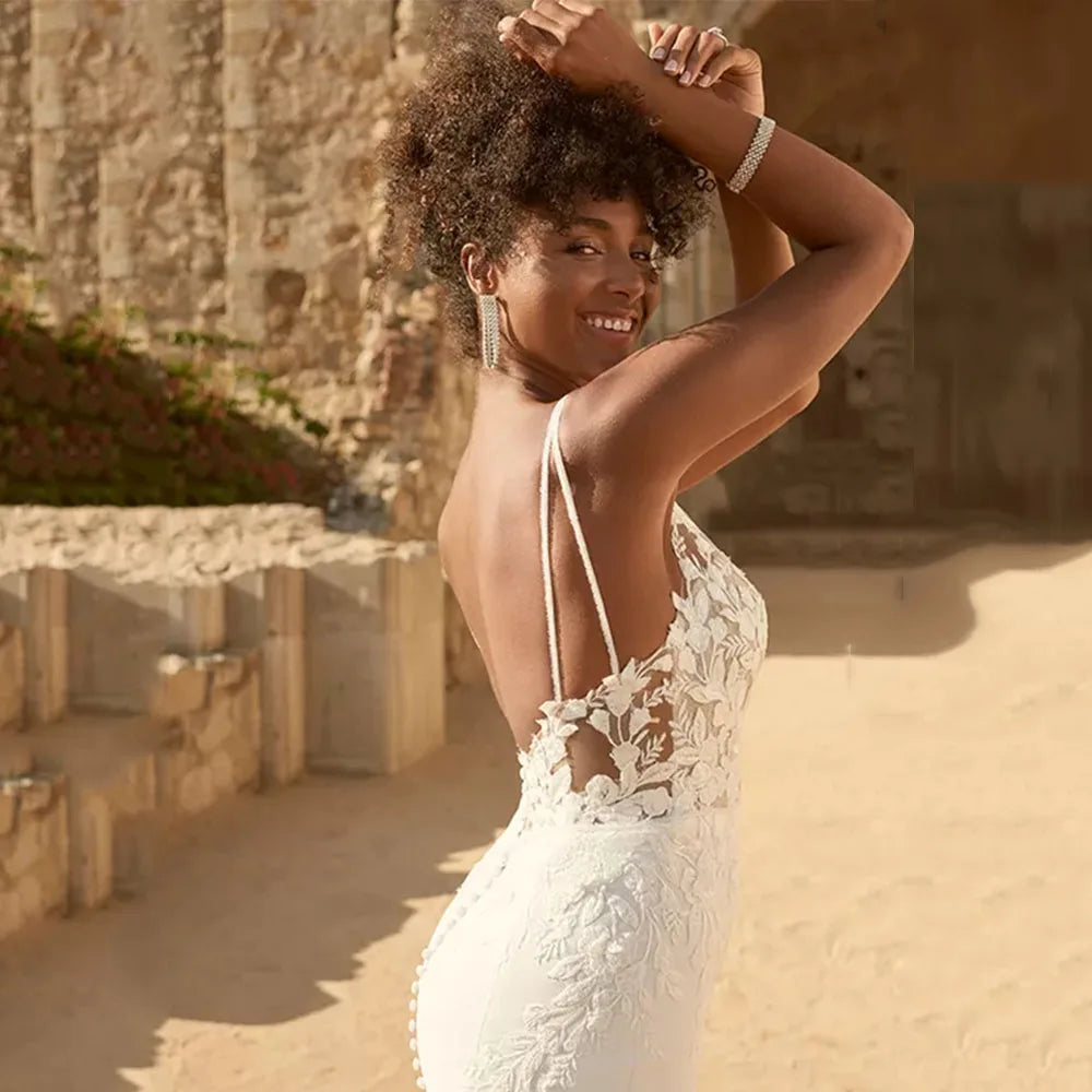 Expertly crafted with delicate lace appliques, the Dress Marietta is a stunning wedding dress with spaghetti straps and a flattering mermaid silhouette. Perfect for a beach wedding, the backless design adds a touch of allure to this elegant gown. Embrace your inner bride in the Dress Marietta.