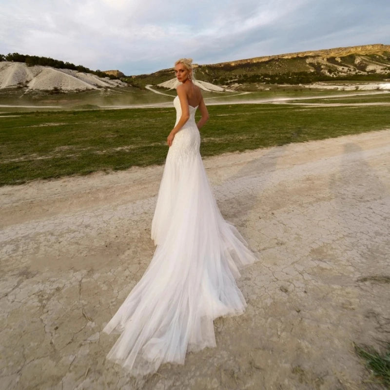 Elevate your wedding day with the grace and beauty of our Robe Finetta. Crafted with a strapless sweetheart neckline and mermaid silhouette, this dress adds a touch of elegance to your special day. The intricate sequin detailing and beachy vibes make it the perfect choice for a seaside celebration.