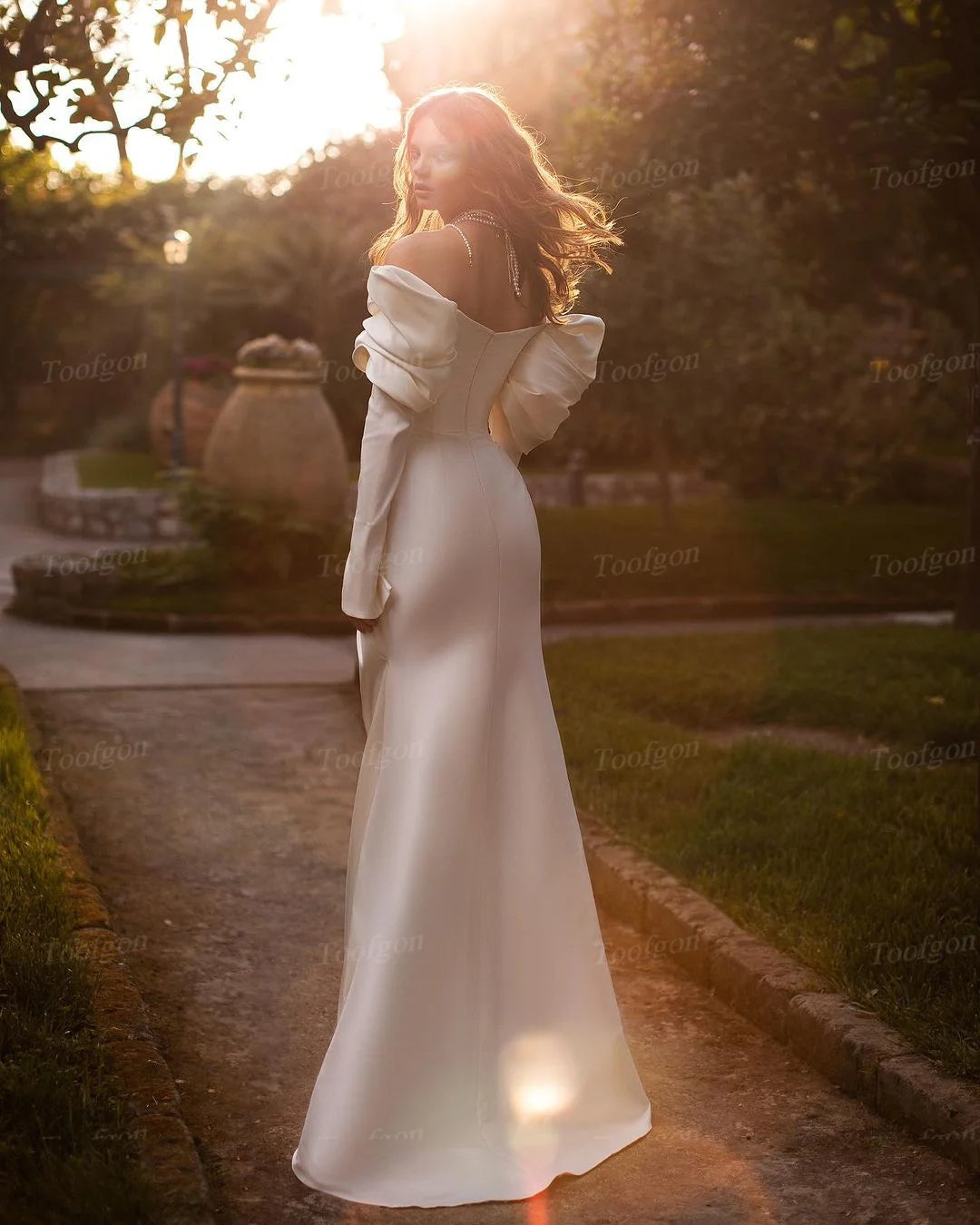 Indulge in the luxurious allure of our Robe Jeanine. Crafted with sumptuous mermaid satin, this wedding dress boasts elegant long sleeves and a pleated off-the-shoulder neckline. With its mermaid silhouette, this gown will beautifully highlight your figure. Perfect for the sophisticated bride who wants to make an unforgettable statement on her special day.