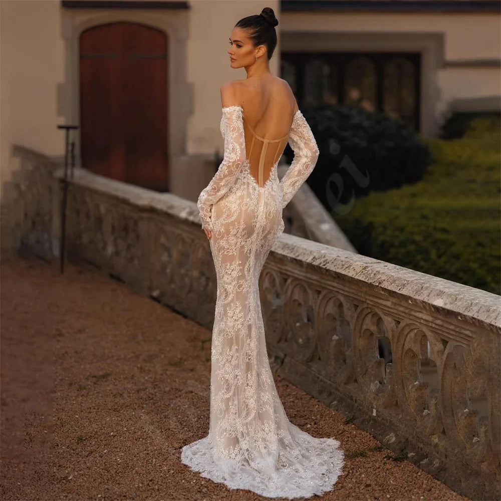 The Robe Rosalinda combines intricate lace details with a mermaid silhouette for a charming and elegant wedding dress. With long sleeves and a sweetheart neckline, this dress is perfect for a romantic and timeless look. Stand out on your special day with this stunning dress.