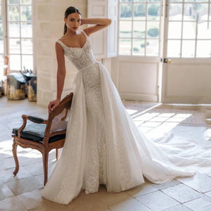 Indulge in sophistication and elegance with our exquisite Robe Fabienne. This square-neck A-line wedding dress features intricate lace appliques and sparkling sequins, exuding the charm and grace of a true bride. Crafted with luxurious tulle, the sweep train adds a touch of romance to this stunning gown.