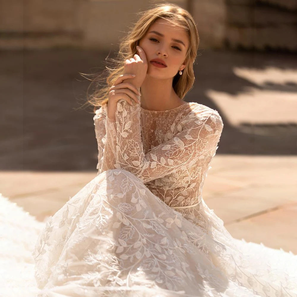 Indulge in the luxury of our Dress Leontine, a custom-made masterpiece. The exquisite embroidered tulle, adorned with delicate leaf lace, creates a timeless and sophisticated look. With long lace sleeves, a closed back, and a round neck, this bridal gown exudes elegance and grace.