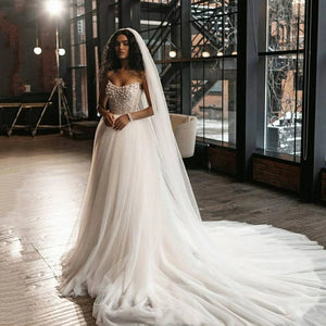 Step into a world of luxury and elegance with the Robe Evaine, a stunning wedding dress adorned with delicate pearls and intricate beading. This court train tulle dress is designed for the daring bride who wants to make a bold statement on her special day. Dare to be different and turn heads with the Robe Evaine!