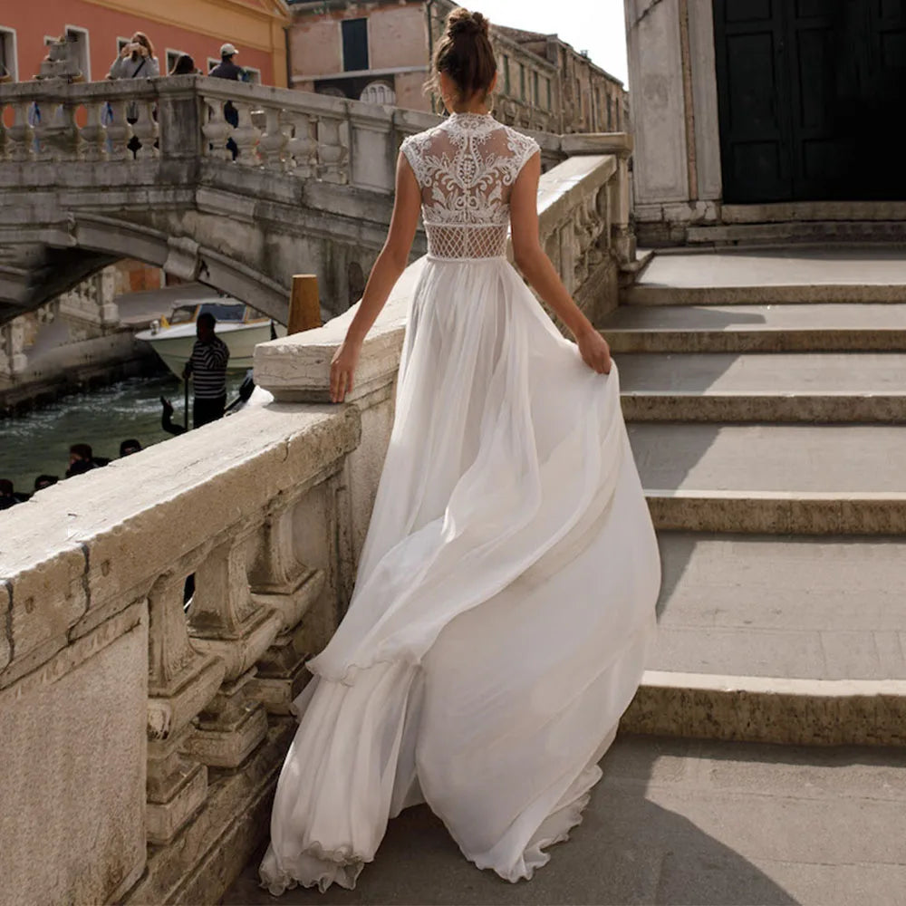 Indulge in the effortless elegance of Dress Zoeline. This sexy sleeveless wedding dress features a high split and delicate lace appliques on soft chiffon. Perfect for bohemian brides seeking sophistication with a touch of sensuality.