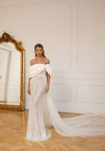 Feel like a princess on your special day with our elegant Robe Genevieve. The mermaid silhouette and spaghetti straps create a chic and stylish look, while the drop off shoulder adds a touch of romance. Perfect for any bride looking for a timeless and sophisticated gown.