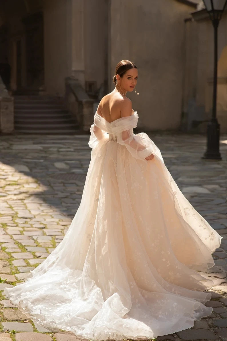 This exquisite Robe Henriette is perfect for the modern princess bride. The elegant long sleeves and voluminous ball gown silhouette create a regal look that will make you feel like royalty on your special day. Made for the romantic at heart, this dress is sure to make you feel like a true princess.