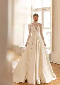 Get ready to walk down the aisle in style with the Robe Milia! This stunning bridal gown features a high neckline and full-length A-line silhouette, perfect for creating a timeless and elegant look. The delicate lace detailing and long sleeves add a touch of romance to this one-of-a-kind dress.&nbsp;