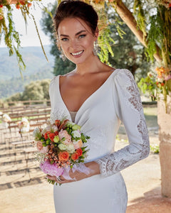 Step into elegance with our Robe Clementine, the perfect choice for your wedding day. This exquisite lace dress features a flattering mermaid silhouette and long sleeves, providing both style and comfort. Make a statement on your special day with this stunning bridal gown.