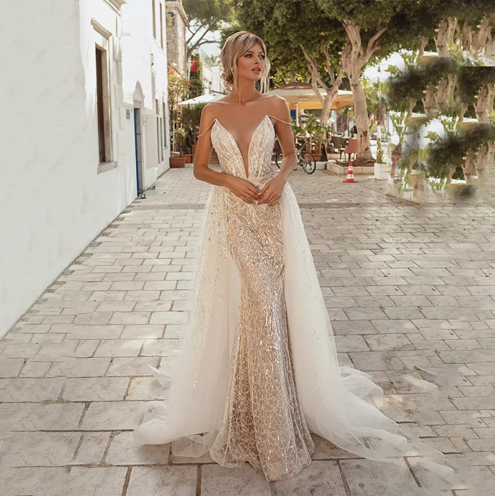 Capture the night in this sparkling Ciel Robe! On-trend and eye-catching, this sequin-embellished dress will make you shine with its plunging neckline, spaghetti straps, and mermaid silhouette. An open back, detachable tulle overskirt, and daring design make for an unforgettable entrance. Be daring and take risks in this wedding gown!